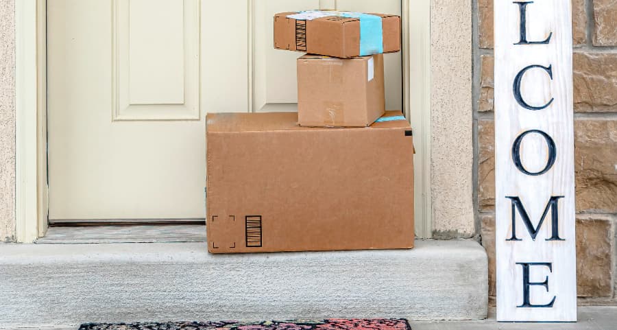 Packages on the doorstep of a home with a welcome sign in Virginia Beach